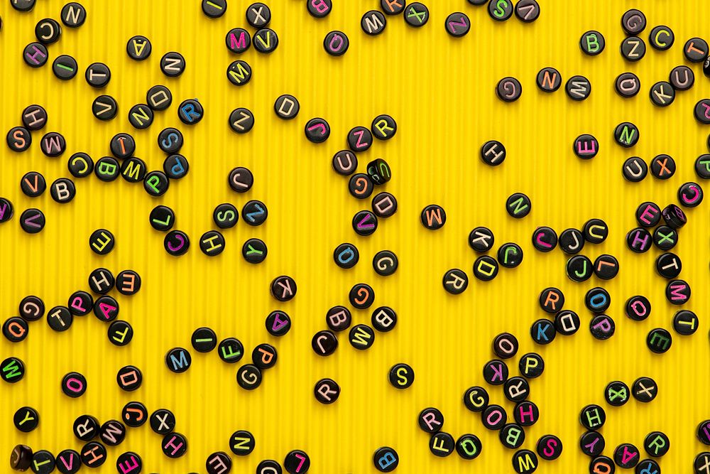 Black alphabet beads yellow wallpaper