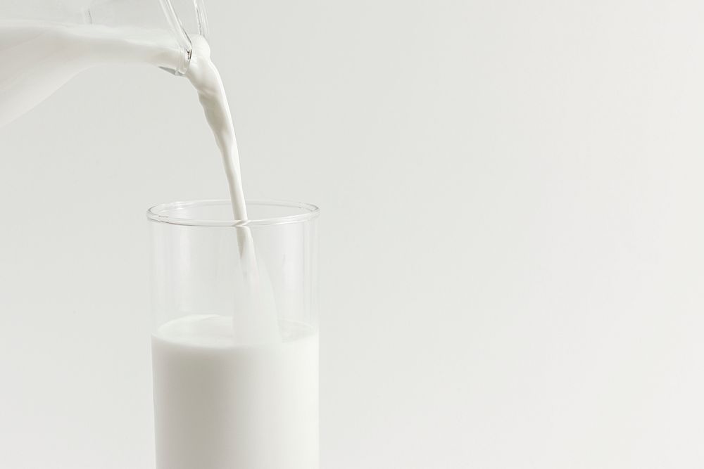 Close up of pouring milk into a glass