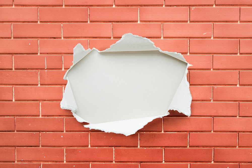 Torn paper on a brick wall