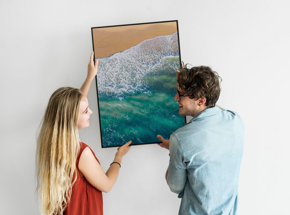 Couple hanging beach photo frame on white wall