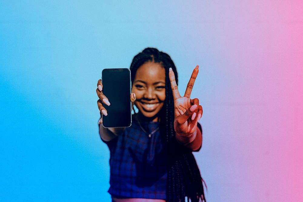 Happy black woman showing her phone