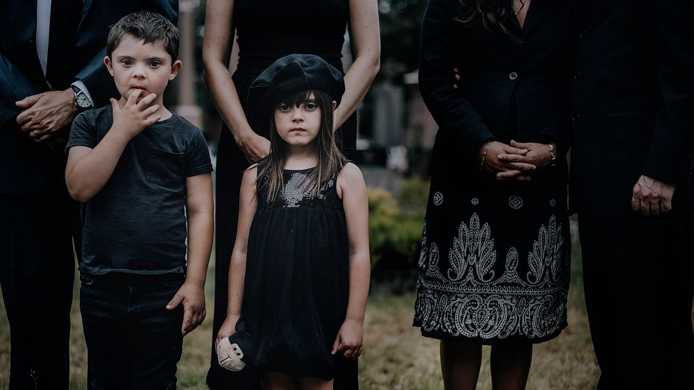 Sad grandkids standing by the grave