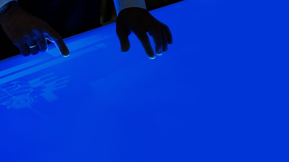 Man using a flat blue touchscreen computer