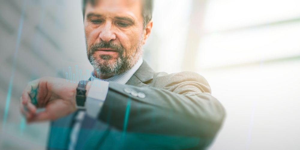 Businessman checking his watch with futuristic graph