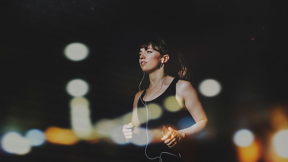 Sporty woman jogging in a dark alley