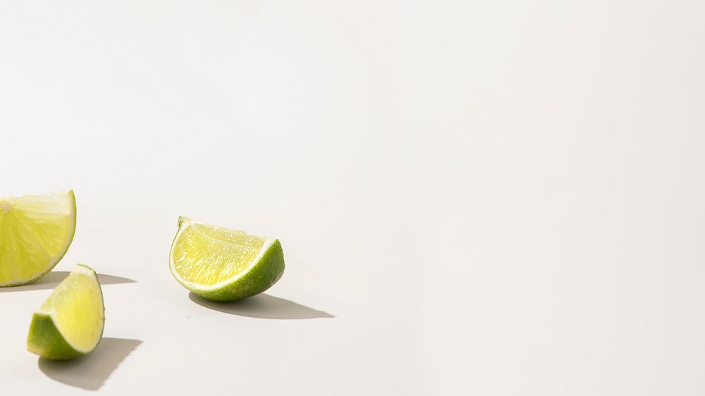 Slices of fresh green lime on white background