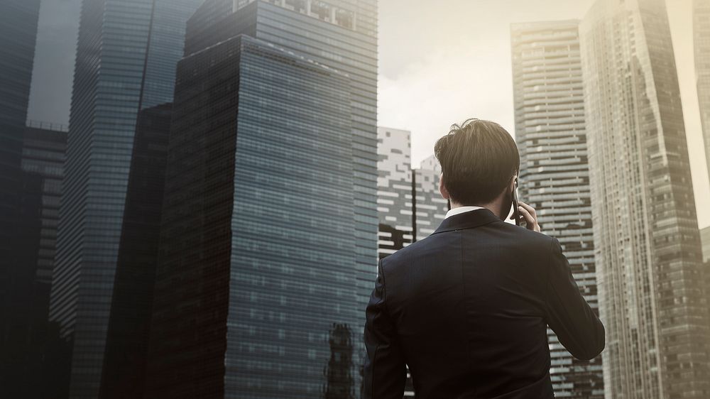 Young businessman on phone city background