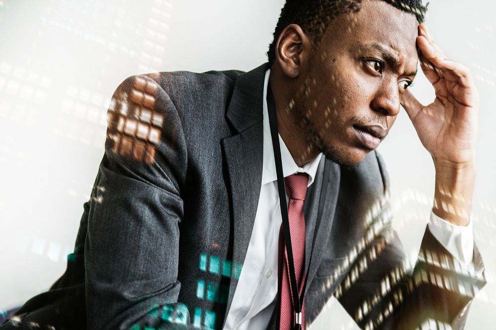 Stressed black businessman with city background
