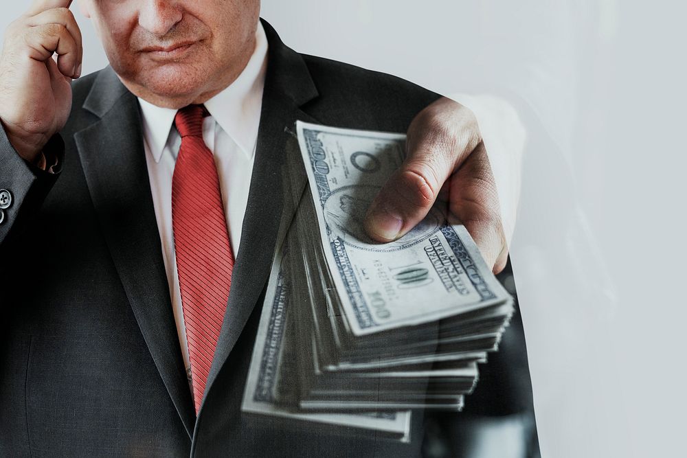 Businessman in suit with a bundle of cash