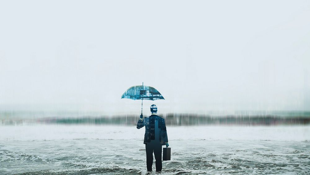 Businessman wearing suit suit with umbrella standing in sea