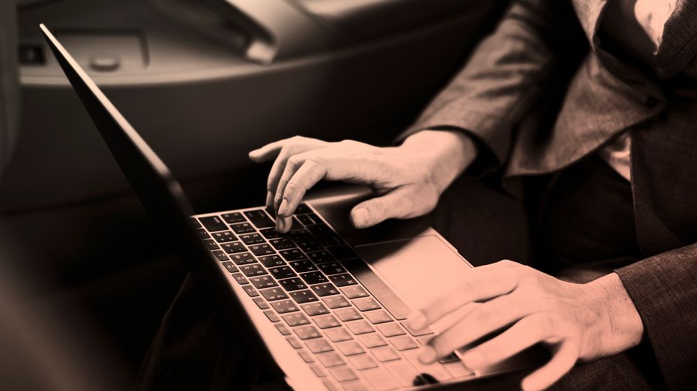 Businesswoman using laptop in car monochrome
