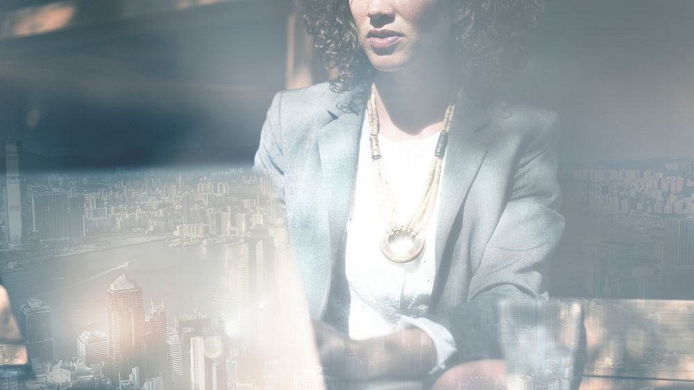 Businesswoman working on a laptop city background