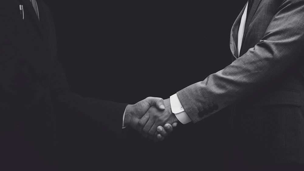 Business partners shaking hands monochrome