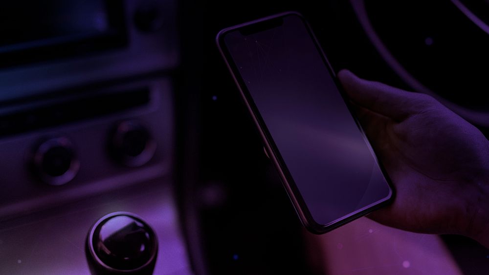 Person using a phone in a smart electric car blog banner