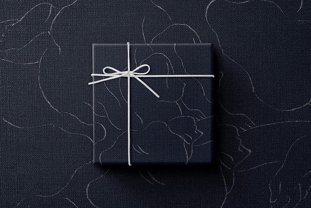 Black gift box wrapped in abstract line drawings