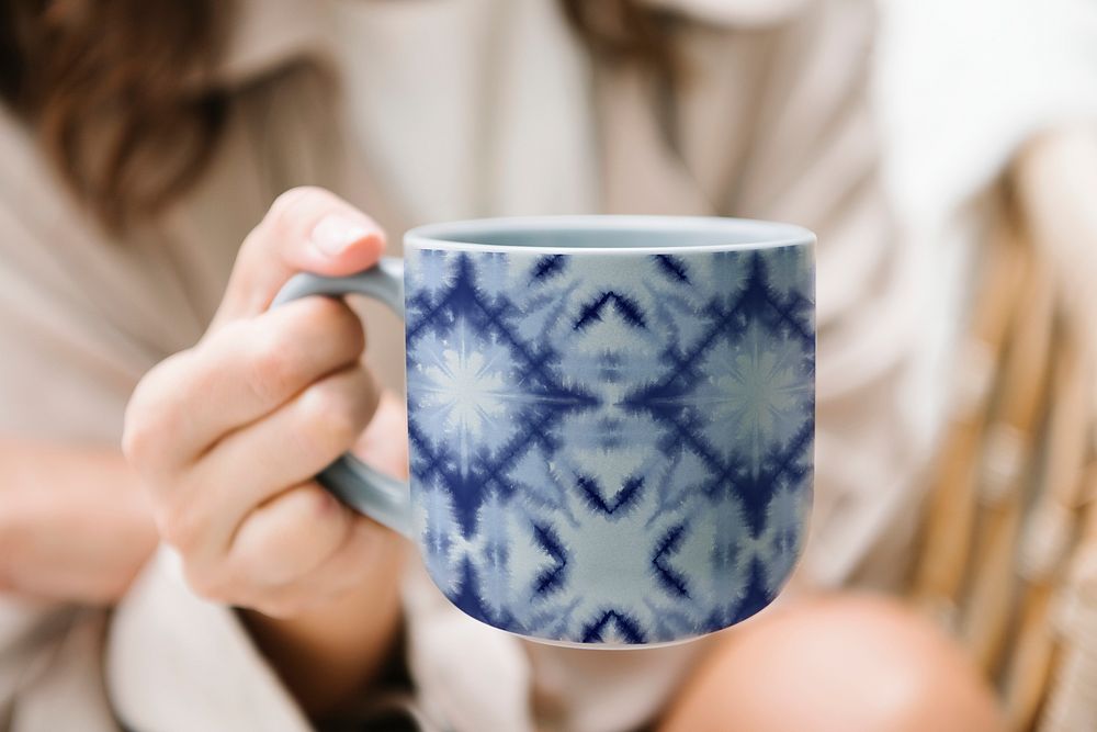 Hand holding a coffee cup in Shibori pattern