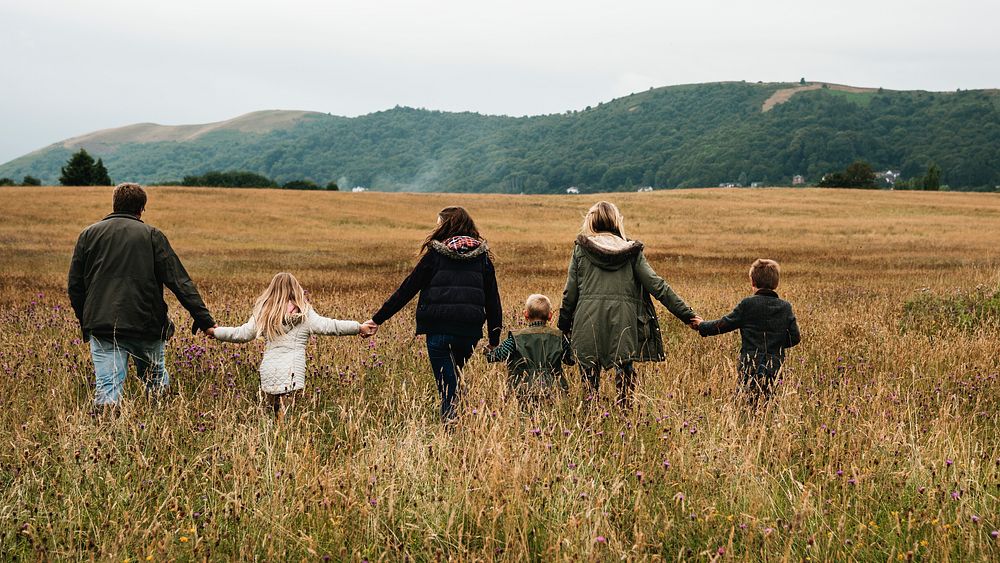 Big family walking hand in hand on the field