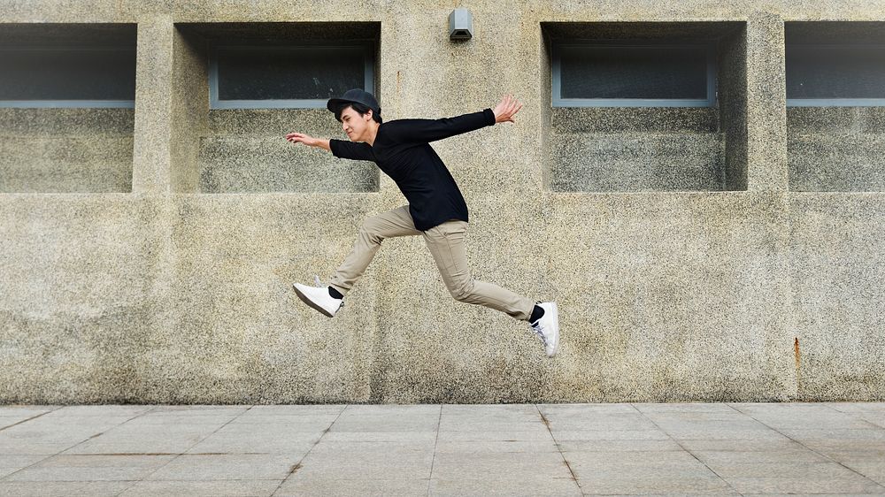 Boy jumping in mid-air on the street