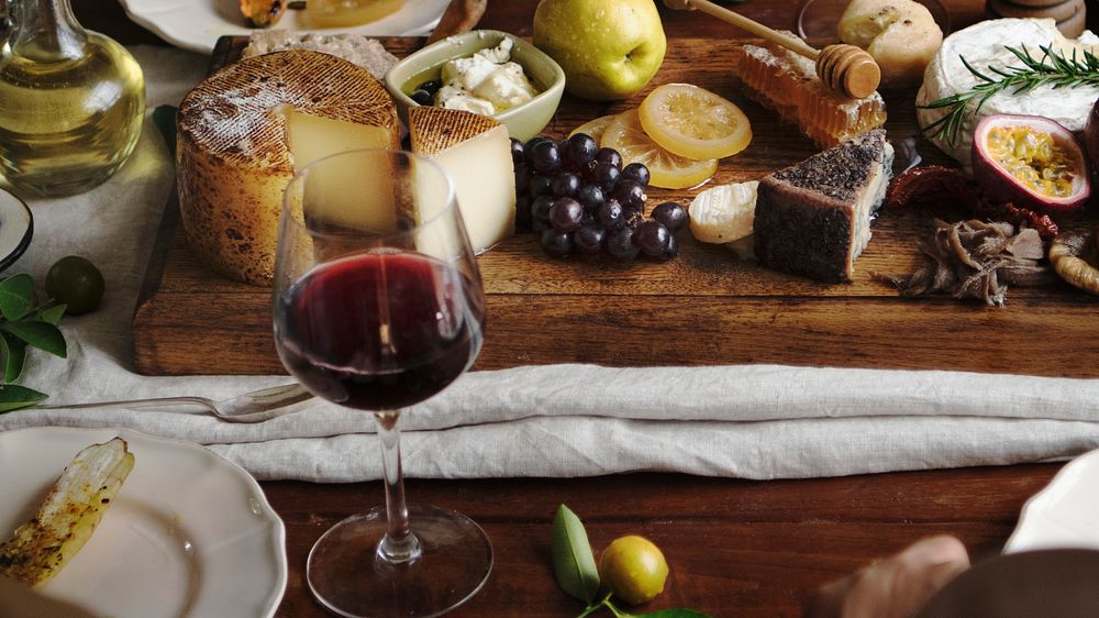 Platter of cheese with seasonal fruits and wine