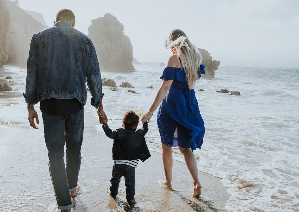 Interracial family walking along the beach in California