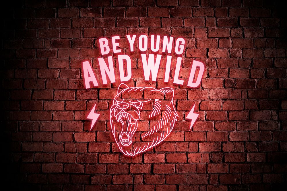 Neon red be young and wild with a roaring bear on a brick wall