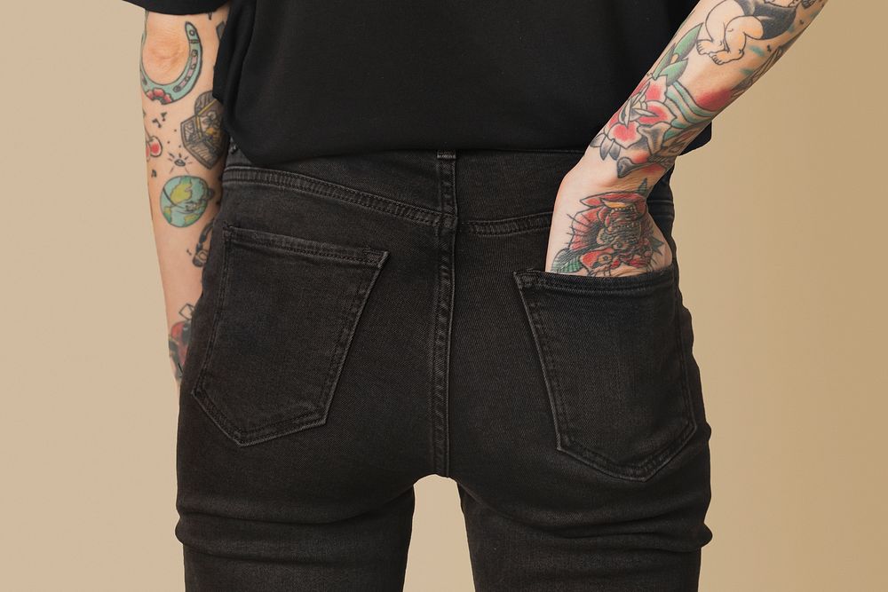 Model with tattoo in black T shirt and jeans