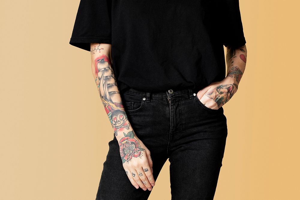 Model with tattoo in black T shirt and jeans