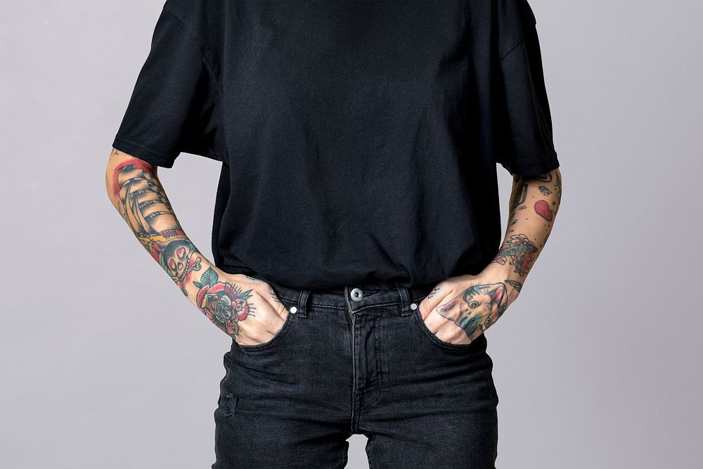 Tattooed woman in black t-shirt and jeans