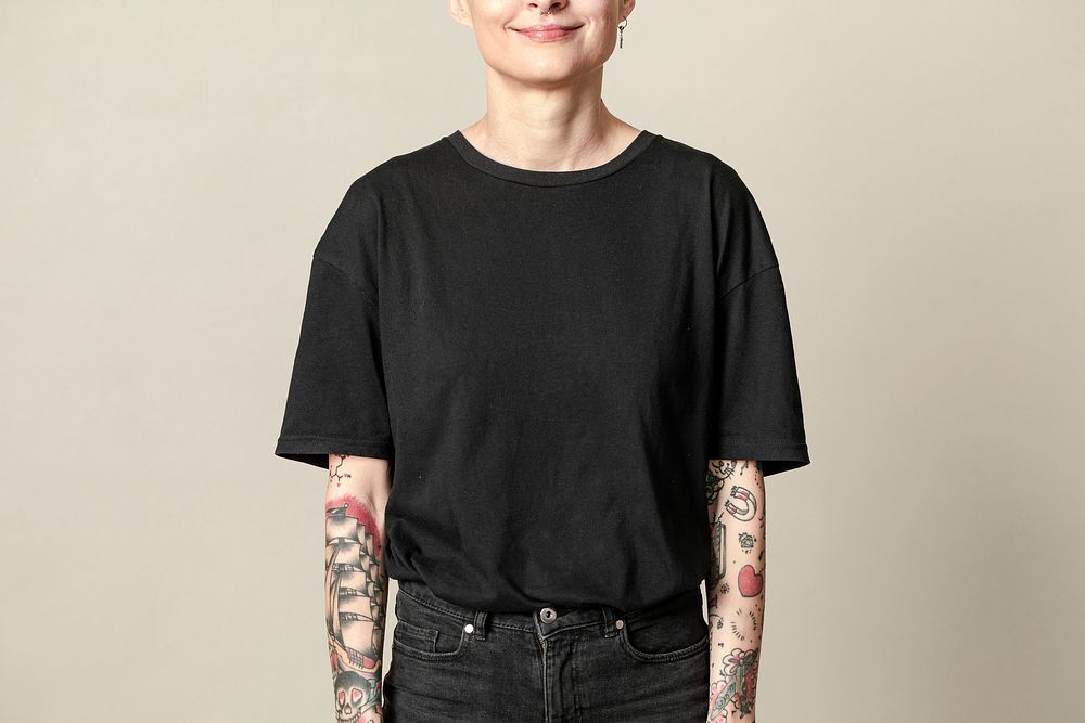 Tattooed woman in black t-shirt and jeans