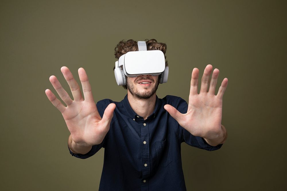 Young man using a VR headset in a green background