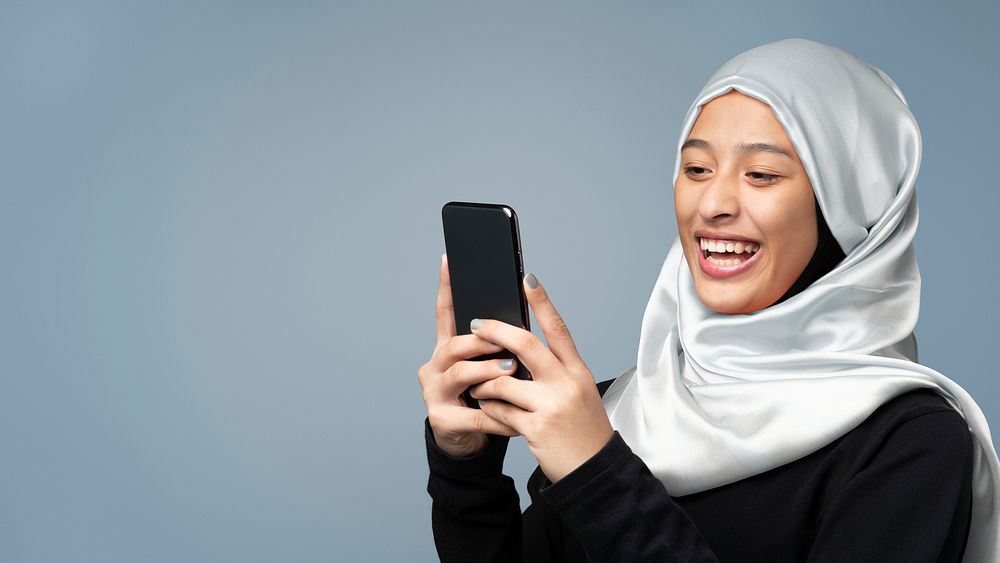 Portrait of a Muslim woman using a mobile phone banner