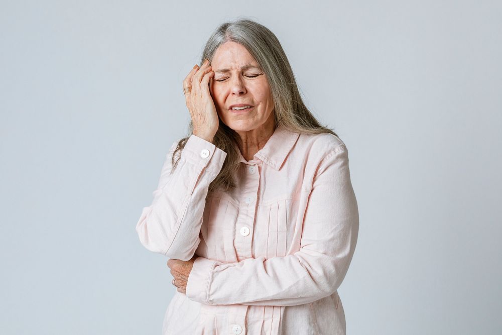 Sick senior woman having a headache during coronavirus pandemic