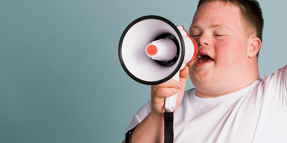 Cute boy with down syndrome using a megaphone to amplify his voice  