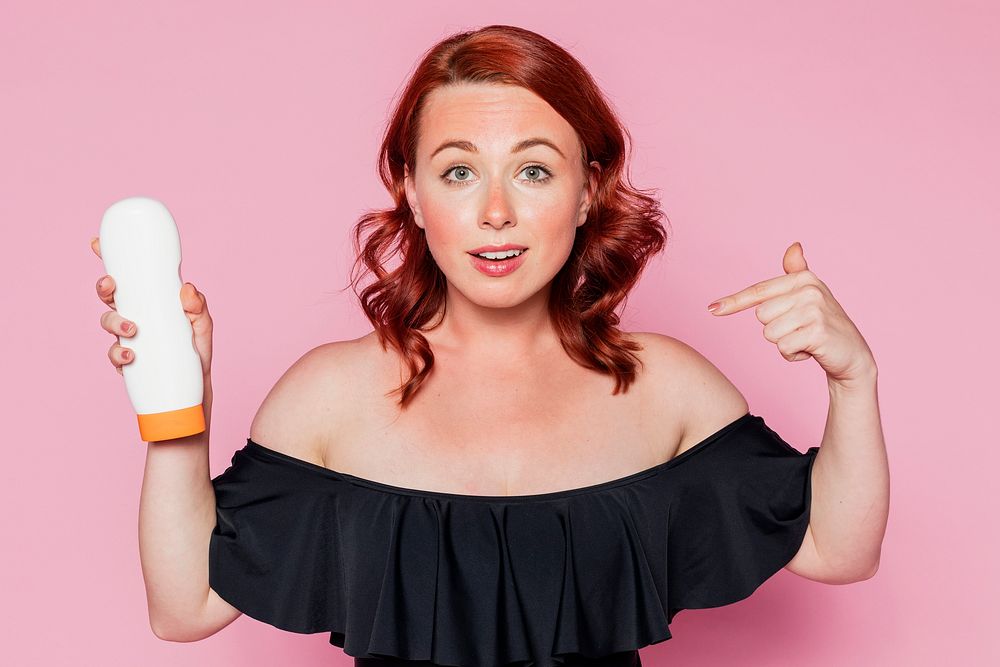 Woman holding a sunscreen tube container