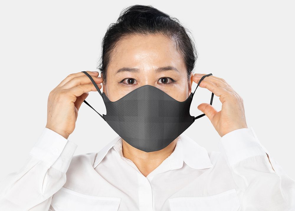 Asian woman putting on face mask