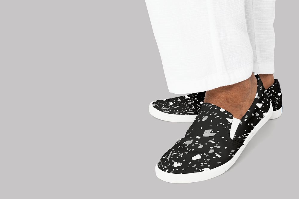 Black slip-on shoes with abstract design casual apparel close up with design space