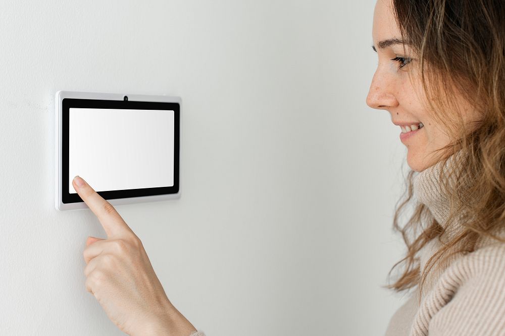 Woman pressing on smart home automation panel monitor
