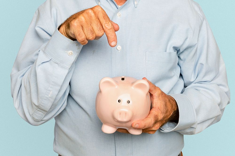 Senior man holding piggy bank for financial savings campaign