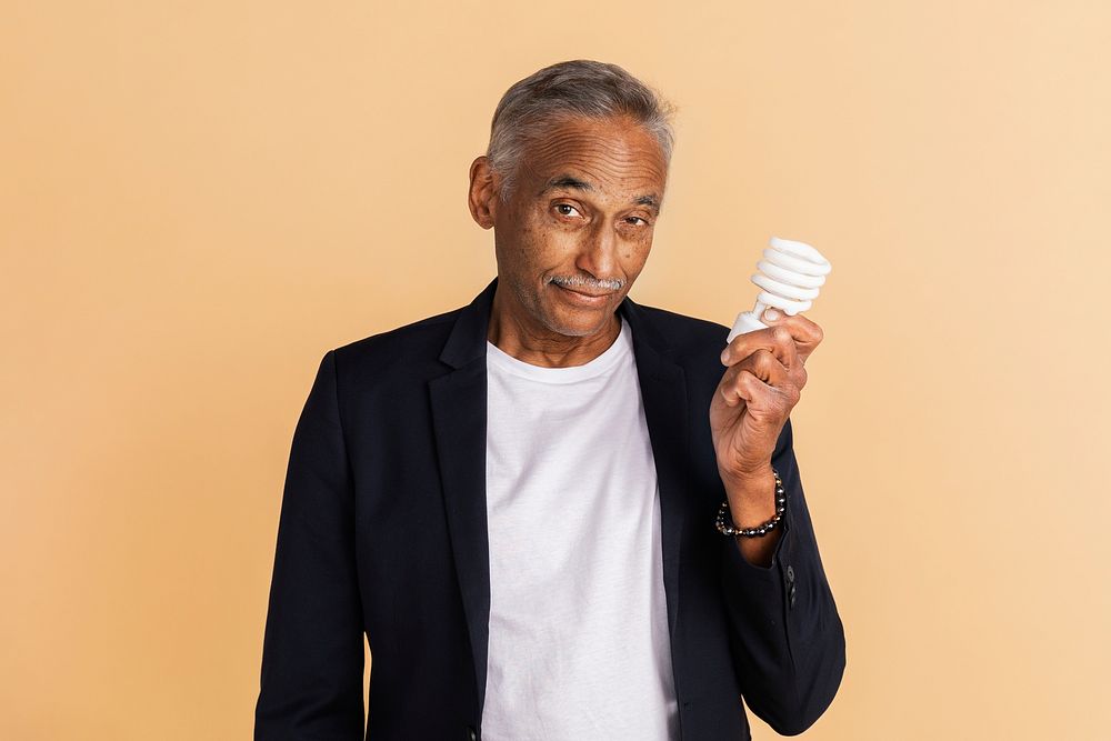Mixed Indian senior man holding a light bulb