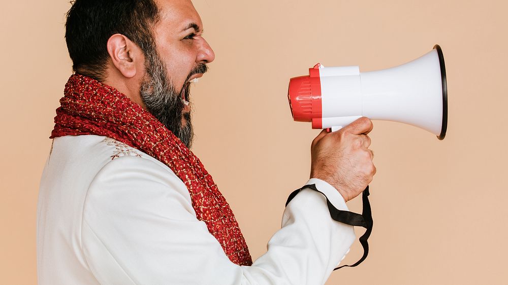 Indian man screaming into a megaphone 