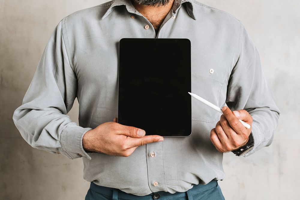 Businessman holding a digital tablet mockup and pointing the screen with a stylus
