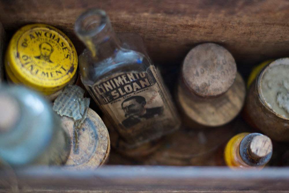 A wooden box filled with vintage medicinal jars and containers. Original public domain image from Wikimedia Commons