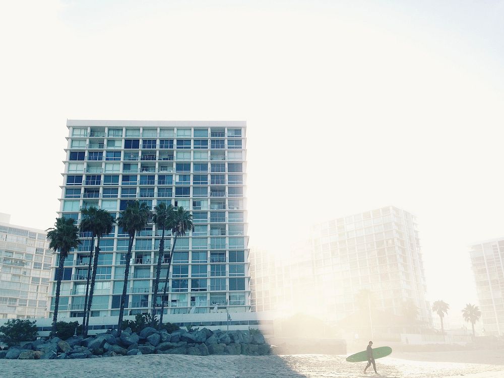 View of high rise beach apartments at Coronado featuring the foggy sky and palm tree. Original public domain image from…