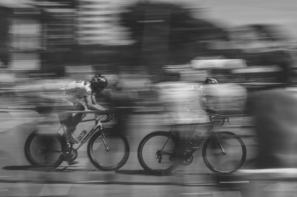A blurry shot of cyclists biking through Curitiba in Brazil. Original public domain image from Wikimedia Commons