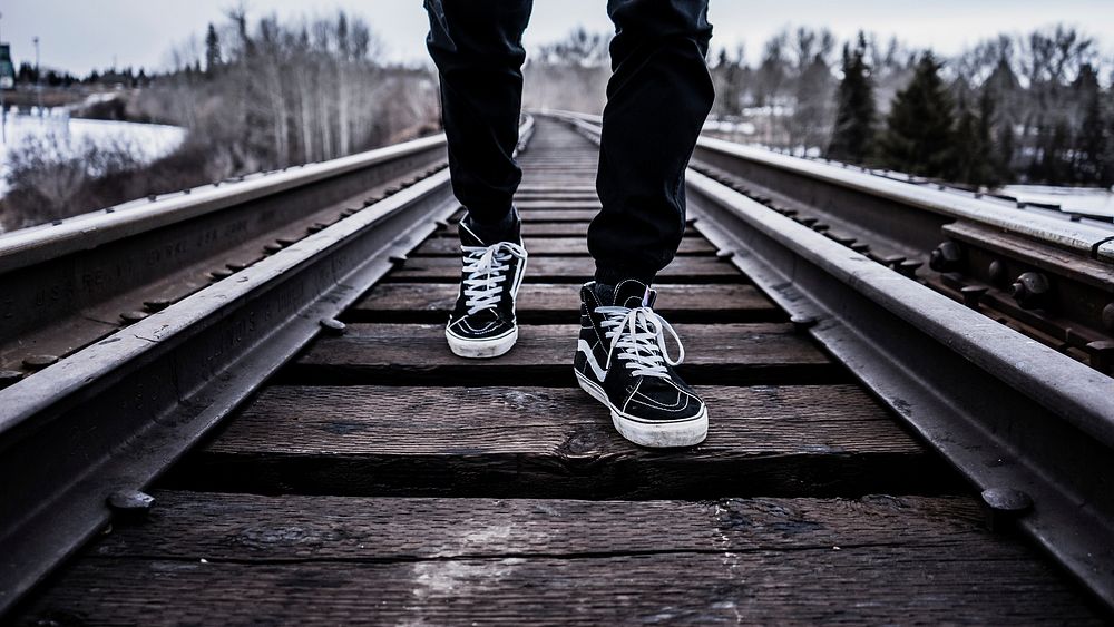 Man walking on a wooden train track Original public domain image from Wikimedia Commons