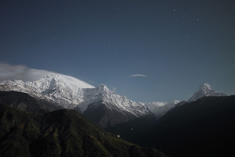 Tall snow-covered mountain peaks under a starry sky. Original public domain image from Wikimedia Commons