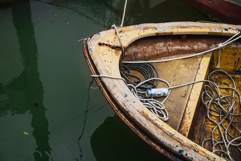 A rusty old boat on the river tied with rope and a beer inside it the mooring, tai O. Original public domain image from…
