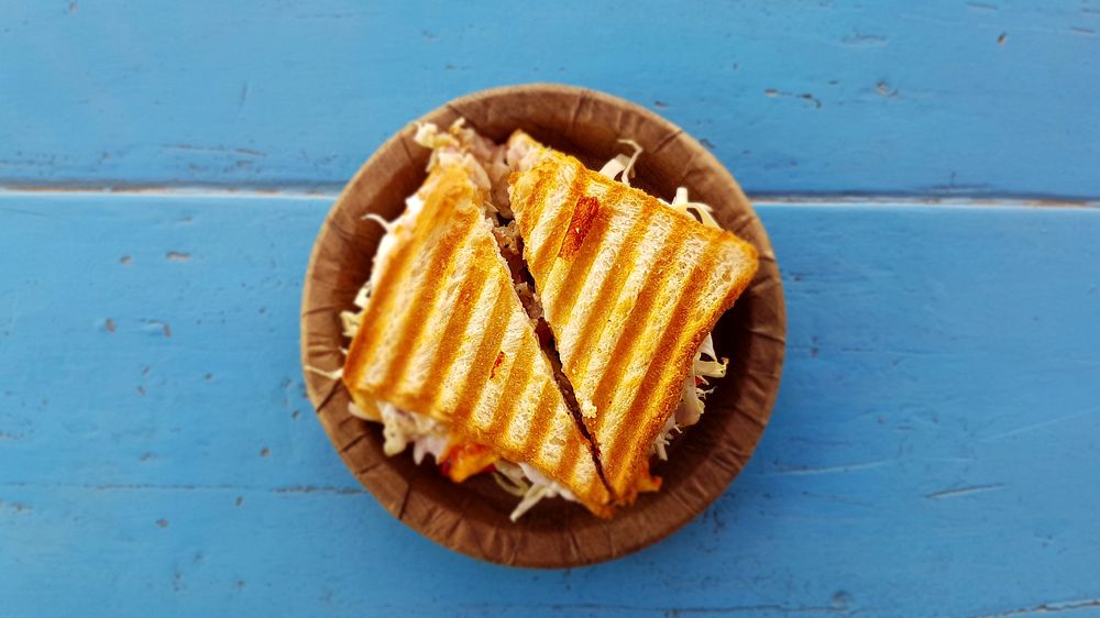 Grilled panini sandwich on a blue background. Original public domain image from Wikimedia Commons