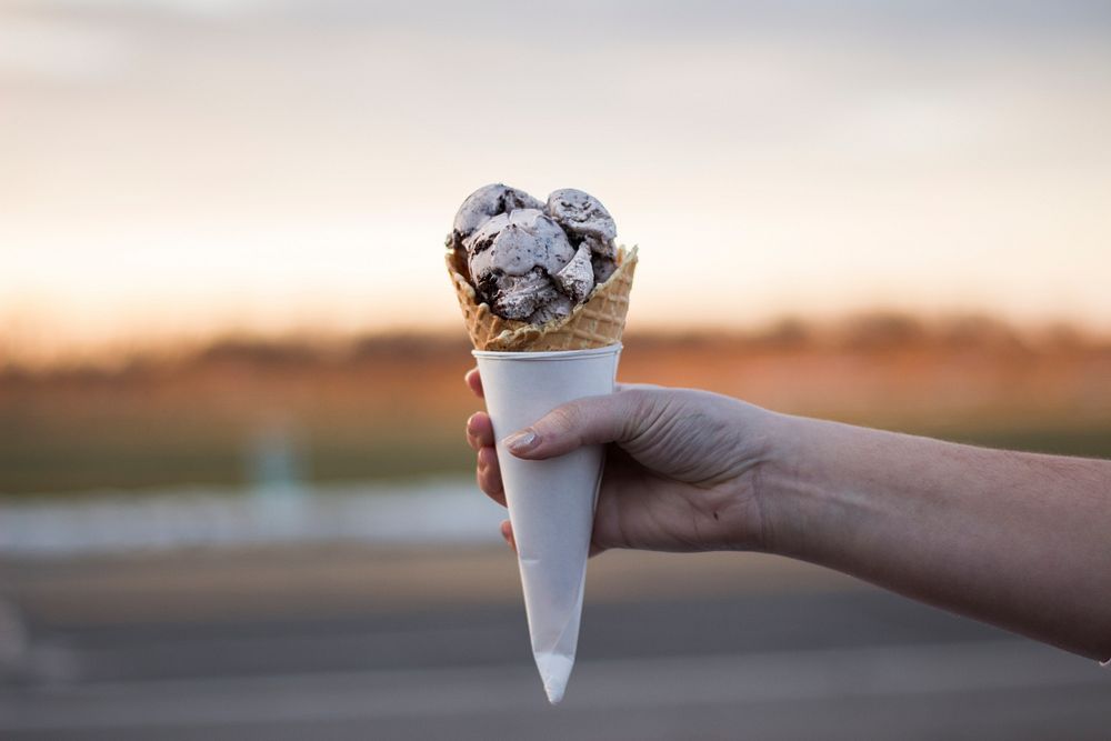 Hand holding scoops of sweet ice cream in a cone. Original public domain image from Wikimedia Commons