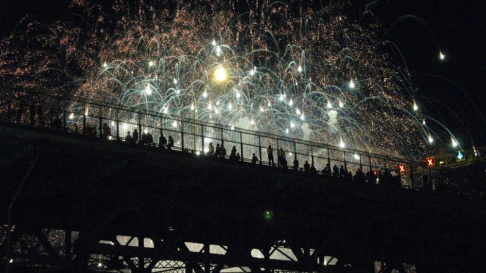 People on a bridge at night in Montreal celebrating with fireworks. Original public domain image from Wikimedia Commons